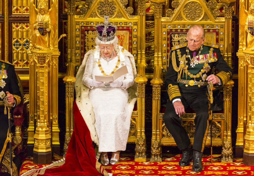 Queen Elizabeth and Prince Philip sitting side by side in ceremonial garb.