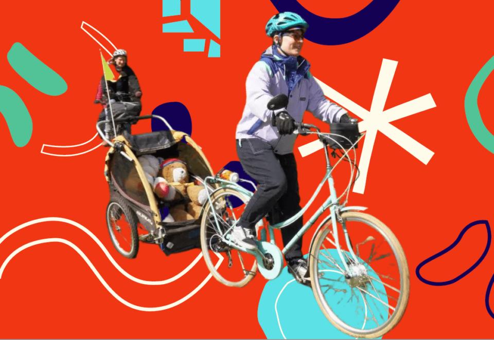 Photo of a woman in a purple coat riding a bicycle. The cycle has a trailer attached to the back which carries two teddy bears. There is another cyclist a little way behind her. The background is red with green, blue, and white patterns.