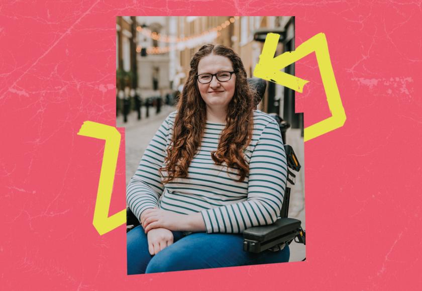 Shona is a white woman with long, curly brown hair. She uses a wheelchair, and wears glasses, a stripey long sleeved shirt, and blue jeans.